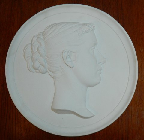 Royal Copenhagen plate in bisque with a motif of a  young woman 19th. century