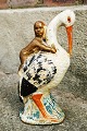 Figure of a stork as a piggy bank with a baby on its back
